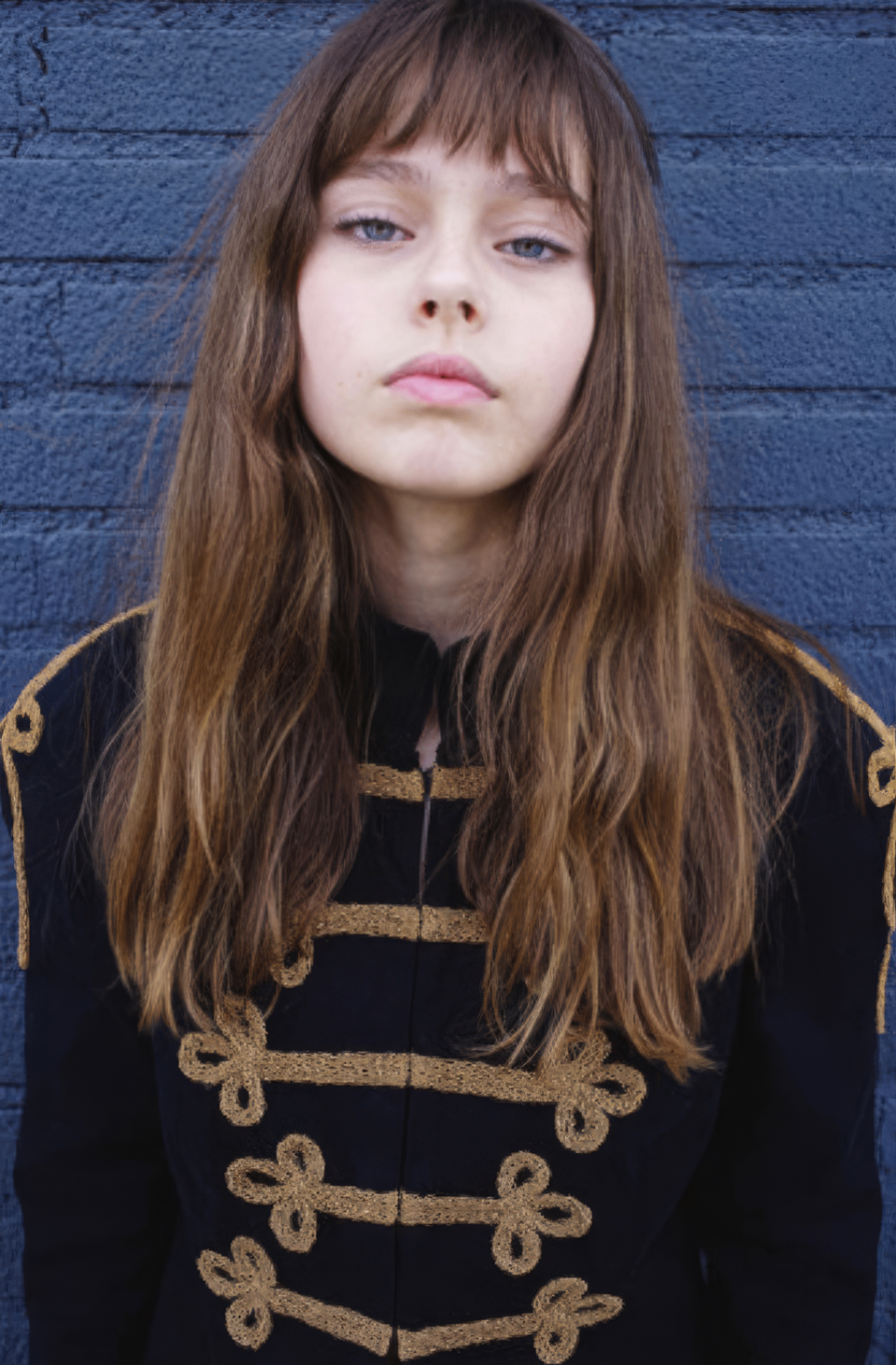Long layered cut with full blunt bangs and natural brunette tones in editorial portrait by Heidi Stanton, hair stylist Los Angeles